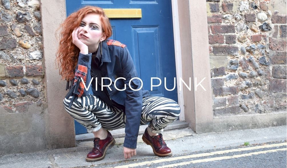 Girl in punk outfit posing by door